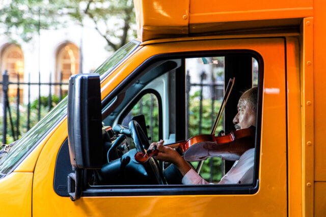 Schulbusfahrer nutzt seine Pause zum Geigenspiel, Financial District, New York, USA